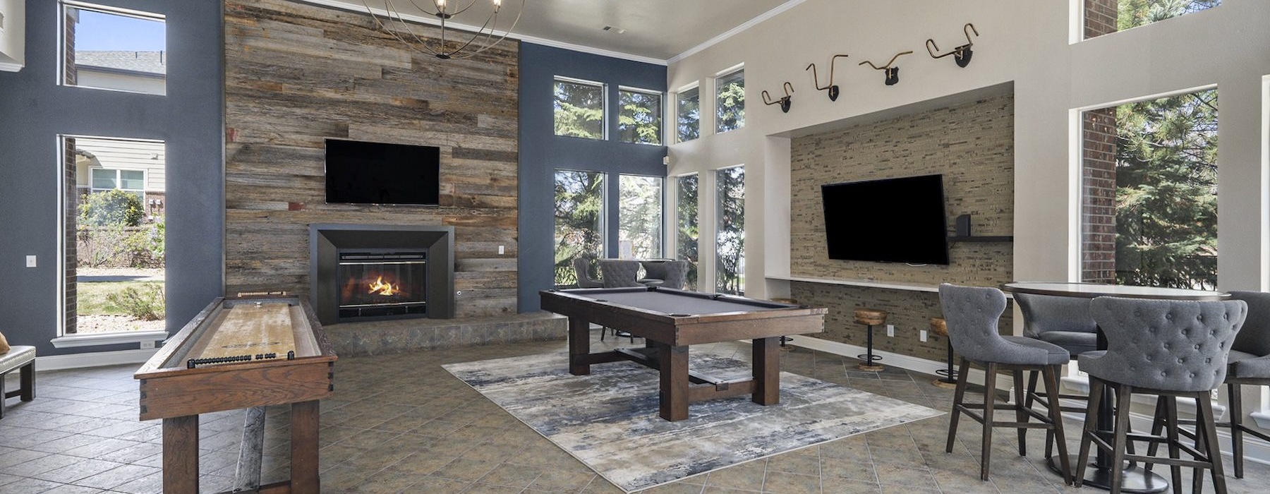 a clubroom with a pool table, tv's and chairs