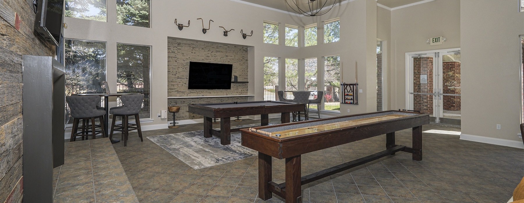 a clubroom with game tables and tv's